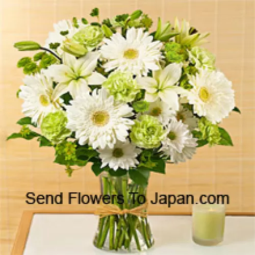 白いガーベラ、白いアルストロメリア、その他さまざまな季節の花が美しくガラスの花瓶にアレンジされています