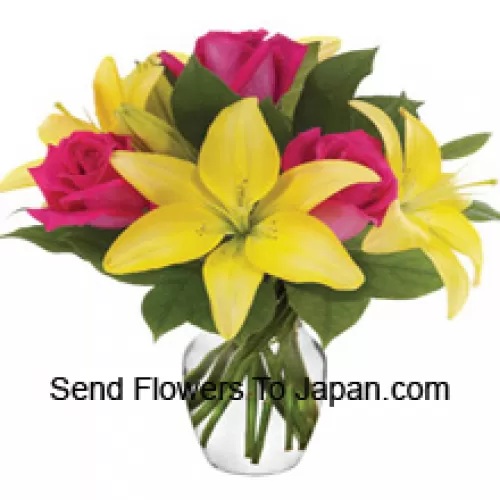 Róże różowe i Lilie żółte z dodatkiem sezonowych kwiatów ułożone pięknie w szklanym wazonie