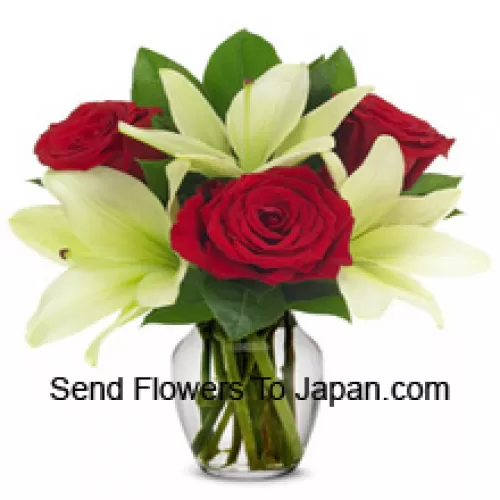 Czerwone róże i białe lilie z sezonowymi dodatkami w szklanej wazie