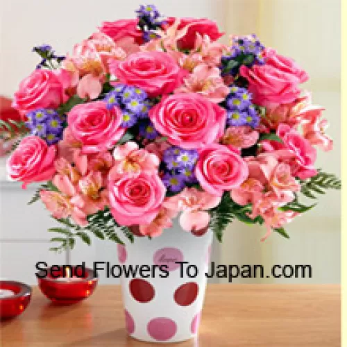Rosas cor-de-rosa, orquídeas cor-de-rosa e flores roxas variadas dispostas lindamente em um vaso de vidro